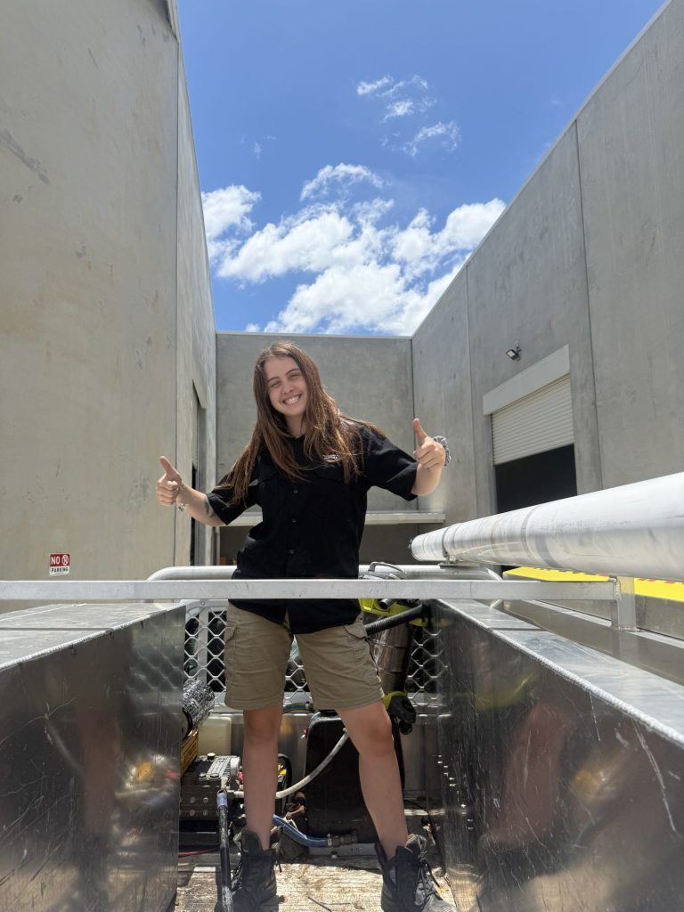 Tahlia, a first-year apprentice, gives a thumbs-up on a sunny day.