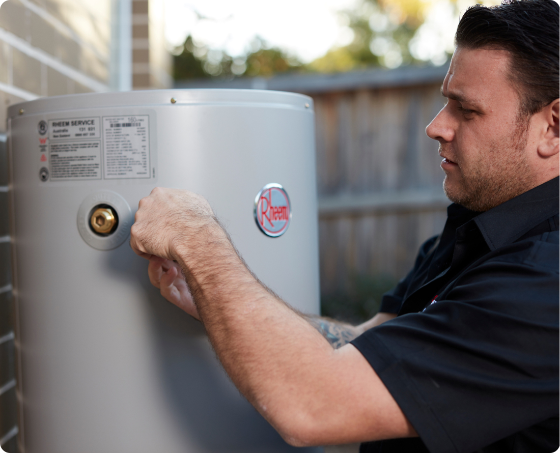 Plumber working on a Rheem hot water system.