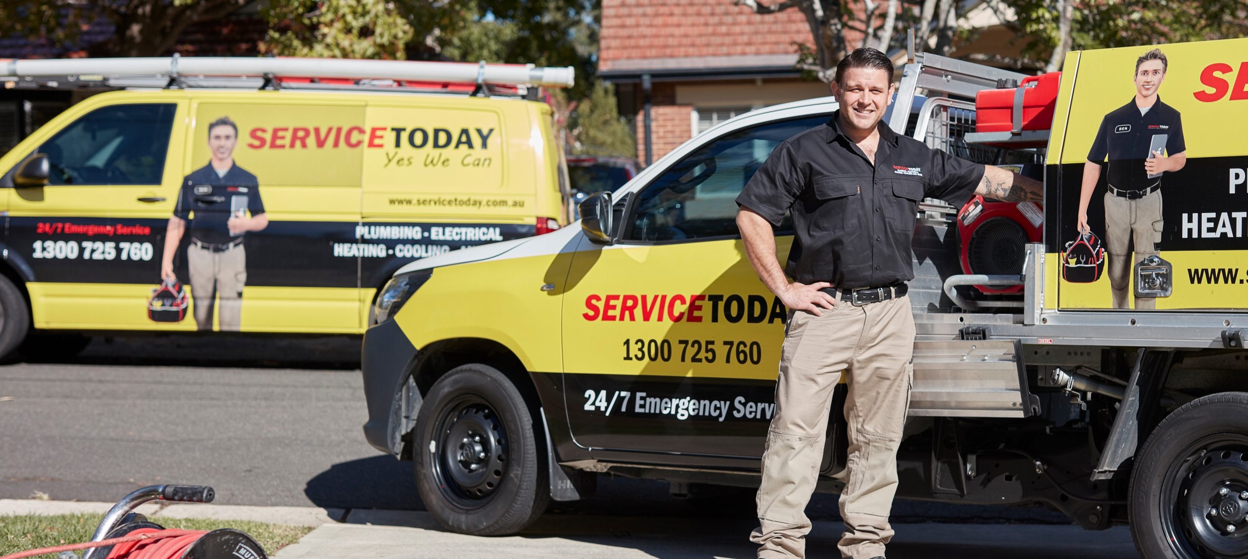 Service Today plumber in uniform next to branded vehicle offering emergency plumbing and electrical services.