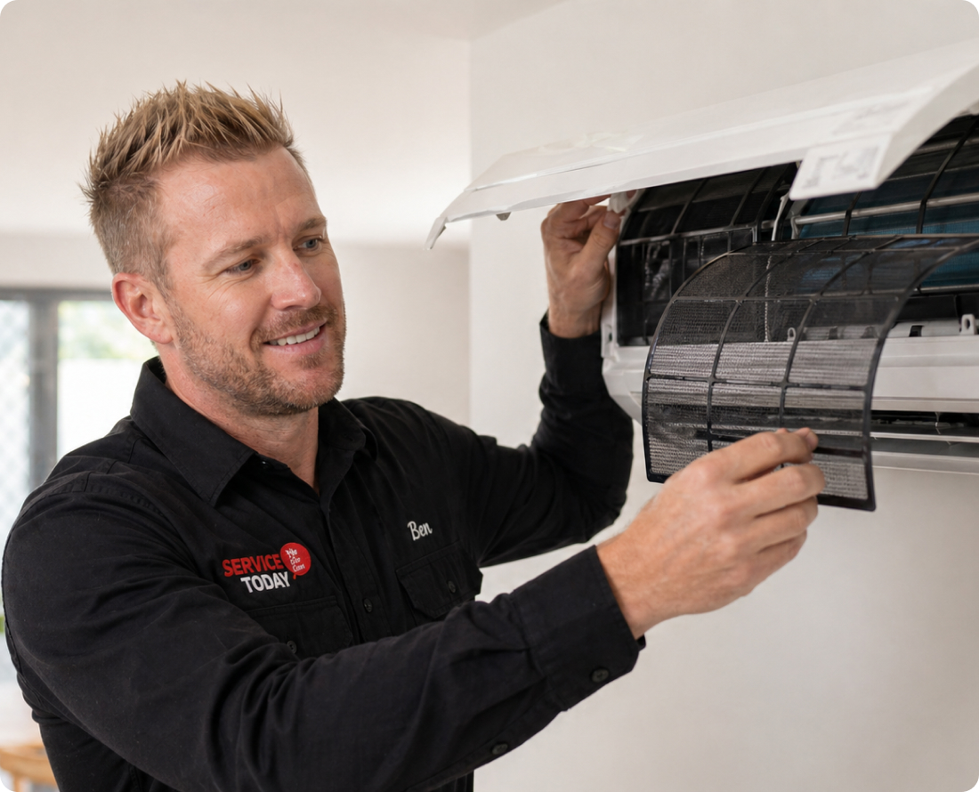 Technician removes dirty air filter from split system air conditioner.