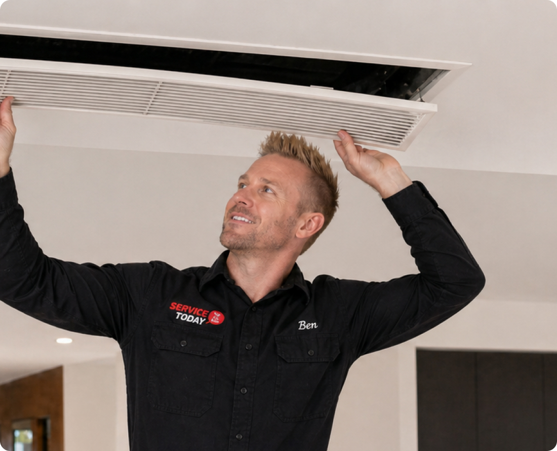 Technician Ben from Service Today inspecting a ducted air conditioning vent.